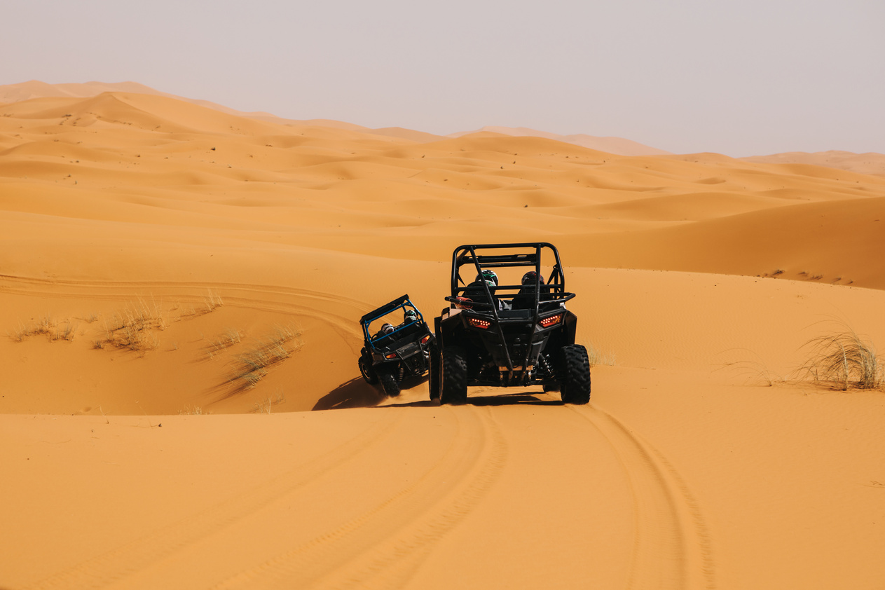 Off road buggies crossing dunes in the desert. Rally raid adventure.